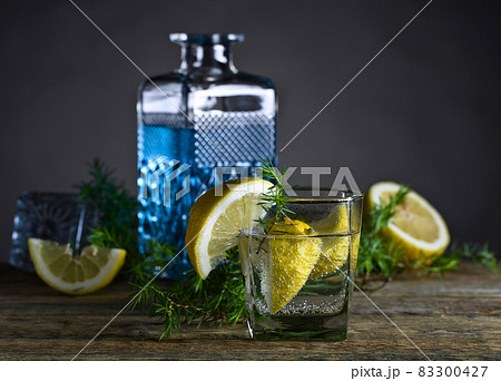 Cocktail with blue gin , tonic and lemon on a old wooden table. 83300427