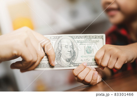 The mother is giving her daughter money as compensation. The mother is giving her daughter money as compensation. 83301466