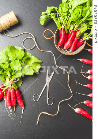 Pink radishes on black table Pink radishes on black table 83302043