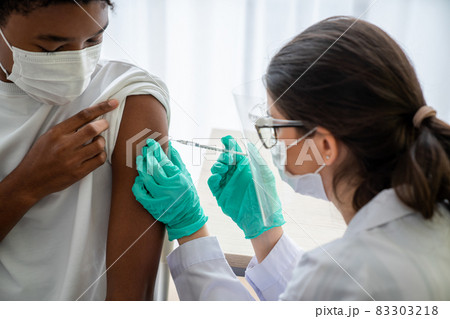 Young man visits skillful doctor at hospital for vaccination 83303218