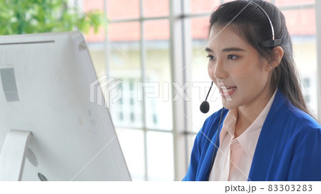 Businesswoman wearing headset working actively in office Businesswoman wearing headset working actively in office 83303283