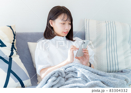 リラックスしてスマホを操作する女性 83304332