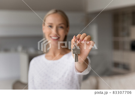 Close up smiling young woman holding keys in hands. Close up smiling young woman holding keys in hands. 83307706