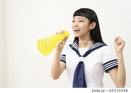 セーラー服を着てメガホンで声援を送る女子高生 83310398