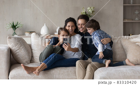 Happy friendly family with kids using cellphone. 83310420