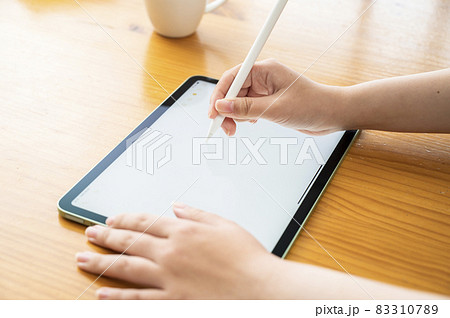 タブレットにペンで作業する女性の手 83310789