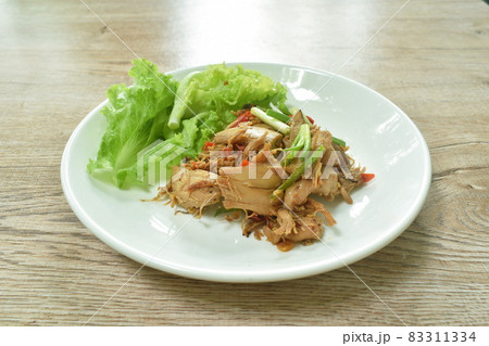 spicy fried roasted chicken meat with chili dressing slice spring onion with lettuce on plate 83311334