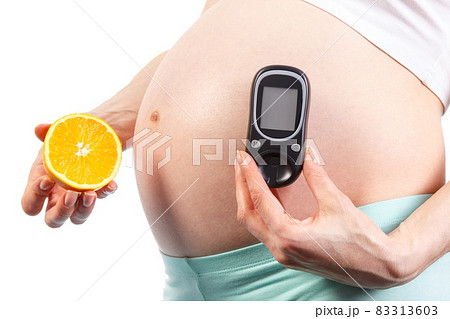 Pregnant woman with glucometer and orange, diabetes and healthy nutrition during pregnancy Pregnant woman with glucometer and orange, diabetes and healthy nutrition during pregnancy 83313603