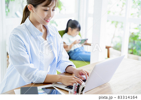 自宅でパソコンに向かって仕事をする母親 83314164