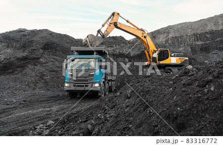 Large quarry dump truck. Loading the rock in dumper. Loading coal into body truck. Production useful minerals. Mining truck mining machinery, to transport coal from open-pit as the Coal Production 83316772