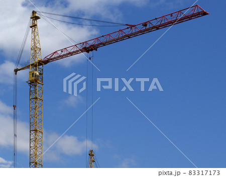 Elevating construction crane against the blue sky in a fair weather 83317173