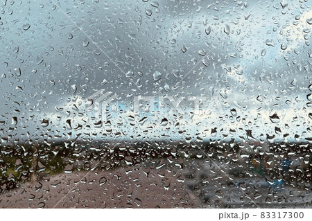 Rain drops on the clear glass. Beautiful raining sky with city background 83317300