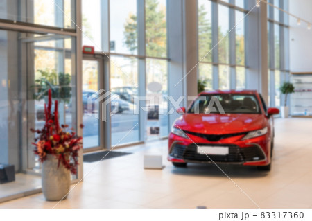 spacious car dealership with an expensive red car, photo with blur 83317360