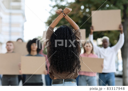 Unrecognizable long-haired woman leading group of protestors 83317948