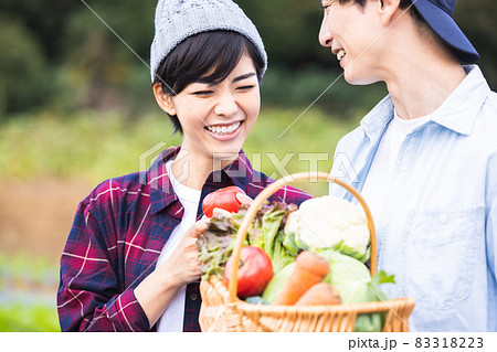 畑で野菜を収穫するカップル 83318223