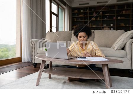 Focused young african american woman managing household budget. Focused young african american woman managing household budget. 83319477