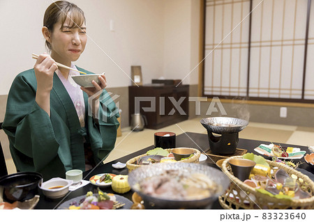 旅館の料理を食べてテンションが上がる若い女性　全国旅行支援 83323640