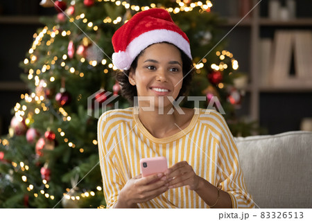 Dreamy smiling young african woman reading wishes with Christmas. 83326513