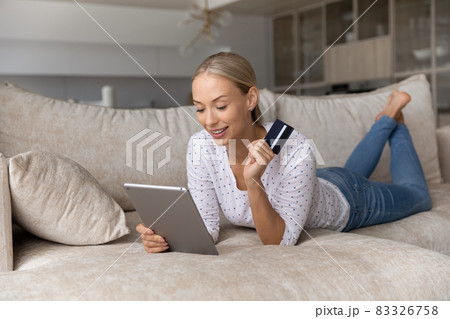 Happy relaxed young woman shopping using digital tablet. Happy relaxed young woman shopping using digital tablet. 83326758