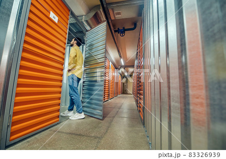 Man entering open garage door in warehouse Man entering open garage door in warehouse 83326939