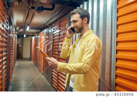 Man with tablet talking on smartphone Man with tablet talking on smartphone 83326956