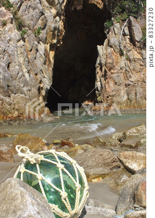 海岸に流れ着いた浮き球　ガラス　岩礁　岩　洞窟　穴　波　自然　砂浜　 83327230