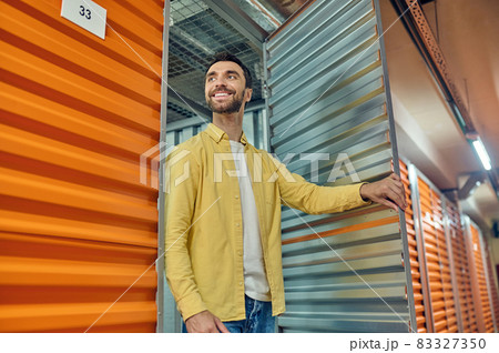 Happy man walking out of warehouse container door Happy man walking out of warehouse container door 83327350