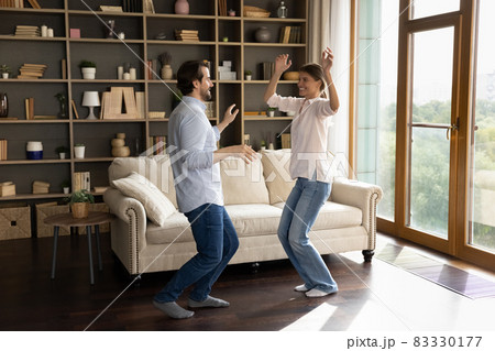 Happy young family couple dancing in living room. 83330177
