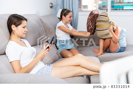 Little girlfriends play pillows on the couch Little girlfriends play pillows on the couch 83331014