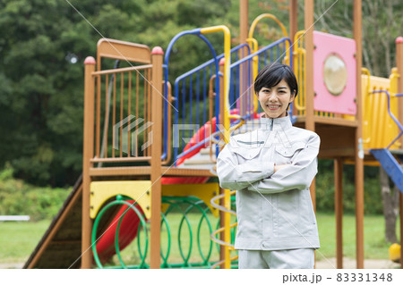 公園に立つ作業着を着た可愛い女性の写真素材 公園に立つ作業着を着た可愛い女性の写真素材