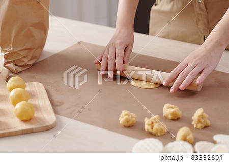 Woman Rolling Out Piece of Dough 83332804