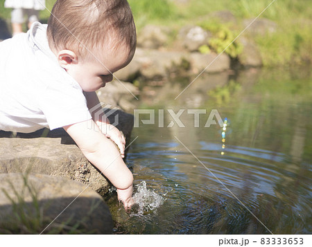 池の水で遊ぶハーフの赤ちゃん 83333653