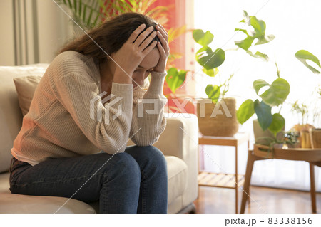 Depressed young woman on sofa at home. 83338156