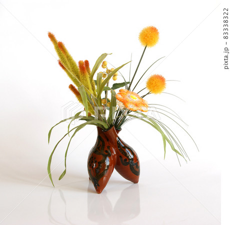 Decorative ceramic vase with a bouquet of artificial flowers on a white background 83338322