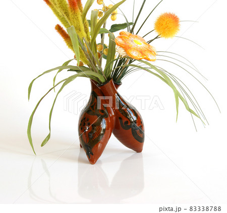 Decorative ceramic vase with a bouquet of artificial flowers on a white background 83338788