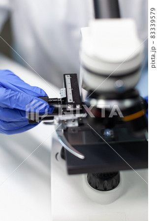 Closeup of biologist woman hand putting transparent glass with blood sample 83339579