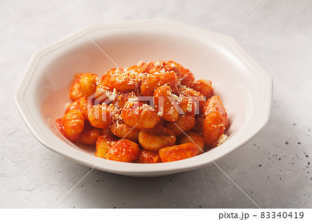 Traditional gnocchi with tomato sauce and cheese in a white plate 83340419