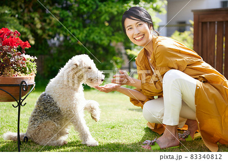 庭で愛犬と戯れるミドル女性 庭で愛犬と戯れるミドル女性 83340812