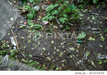 bunch of used dirty syringe leaved after drug injection lying on ground outdoor 83341650