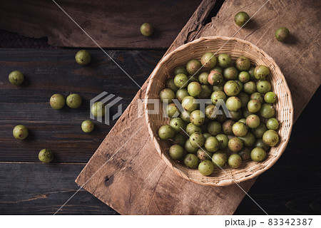 Wild Indian gooseberry or amla in a bamboo basket on wooden background Wild Indian gooseberry or amla in a bamboo basket on wooden background 83342387