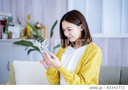 自宅でスマホを見る女性 83342772