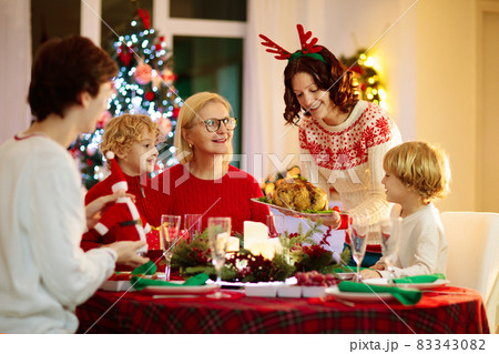 Christmas dinner. Family with kids at Xmas tree. 83343082