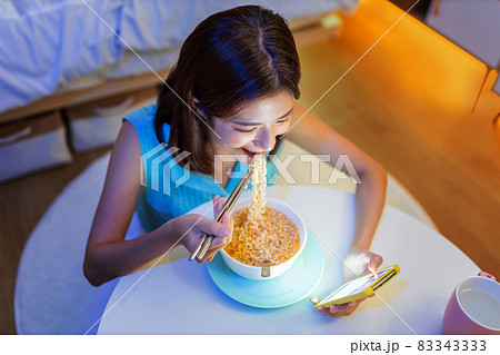 woman eating instant noodles woman eating instant noodles 83343333