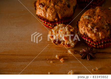 Freshly baked homemade muffins with raisins and carrots. Vegetarian pastries on a wooden background. Place for text. 83345602