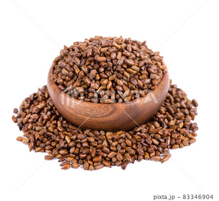 Cassia tora beans in wooden bowl, isolated on white background. Sicklepod or Senna obtusifolia. Clipping path. 83346904