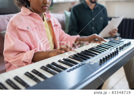 Hands of biracial diligent schoolgirl playing piano keyboard Hands of biracial diligent schoolgirl playing piano keyboard 83348719
