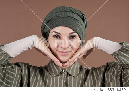 Happy young Muslim woman touching her face by hands Happy young Muslim woman touching her face by hands 83348879