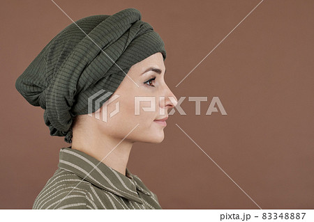 Side view of young serene woman in turban and casual shirt 83348887