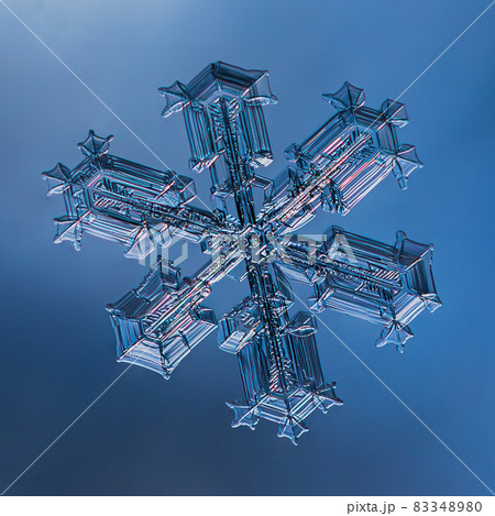 Snowflake on smooth gradient background. Macro photo of real snow crystal on glass surface. This is small snowflake with unusual pattern. 83348980