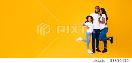 African American man hugging his wife and excited daughter African American man hugging his wife and excited daughter 83350430